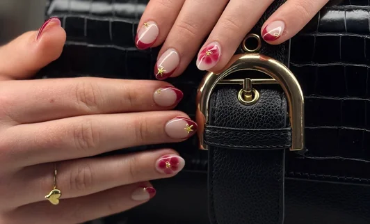French manicure met roze bloemetjes en gouden sterretjes op amandelvorm