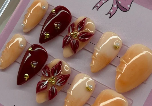 Perzik en bordeauxrode press-on nagels met handgeschilderde bloemen en gouden parels